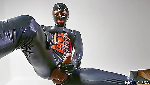 Latexed blonde enjoys her big natural cock in a solo video